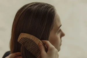Side view of a woman combing her straight brown hair