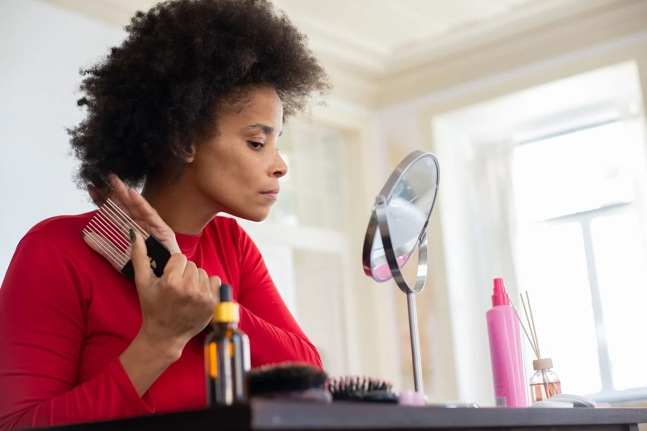 Woman caring for her natural curls beside a mirror