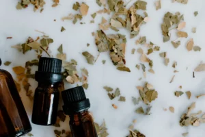 Amber botanical oil bottles arranged beside dried leaves