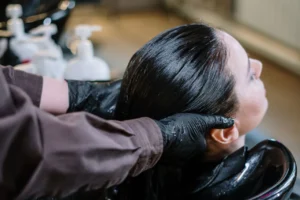 Woman having her dark hair rinsed at a salon basin