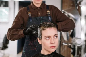 Hairdresser sectioning and caring for a woman’s dark hair