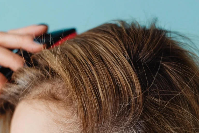 Close-up of a woman brushing her hair near the parting
