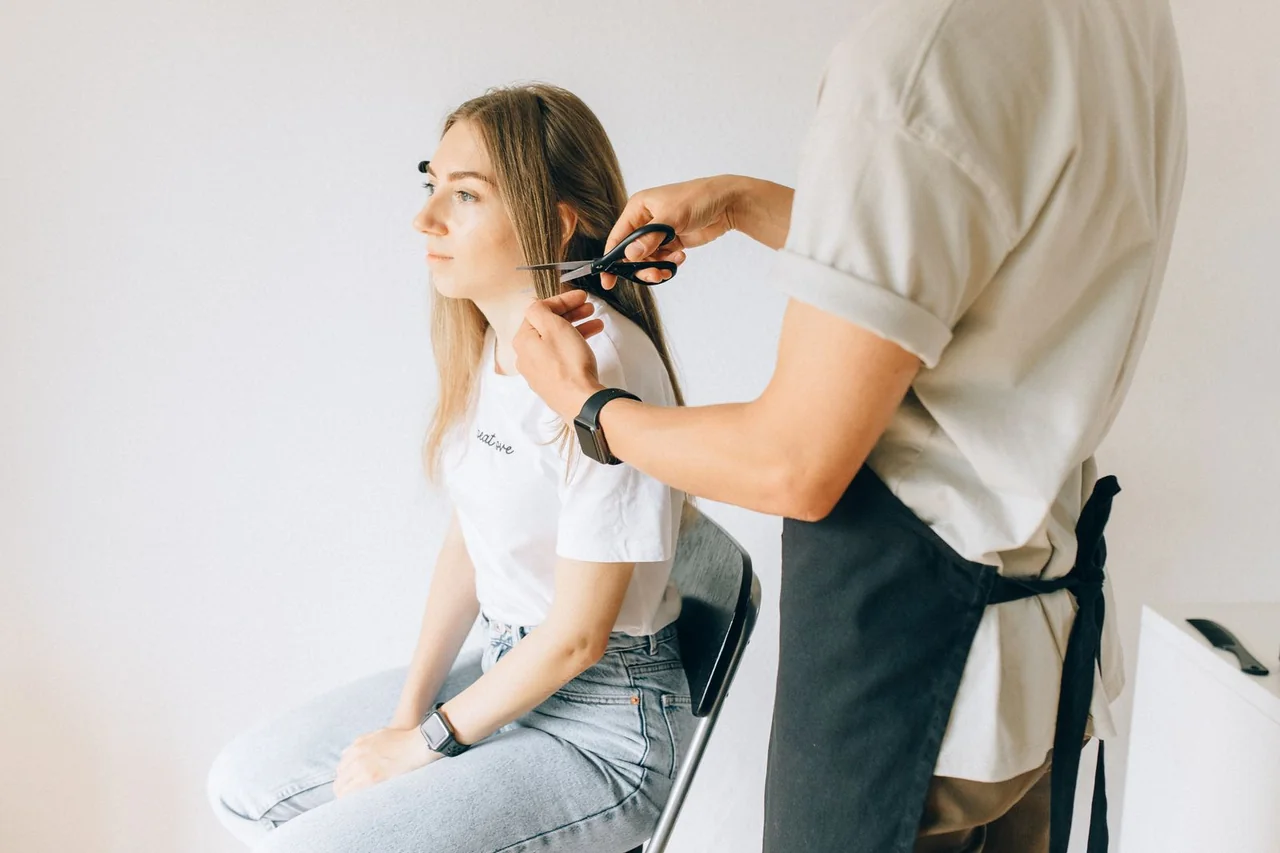 Woman receiving a haircut in a bright, simple salon